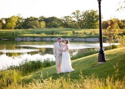 Bride and Goom standing by pond