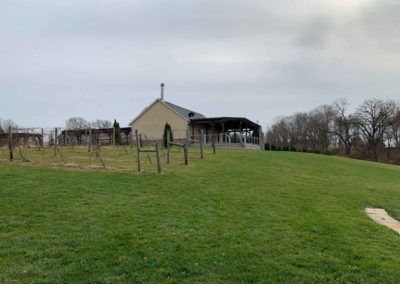 view of the Brooder House porch and vineyard from Grand Gazebo lawn
