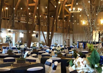 round tables set for a reception inside the Big Red Barn