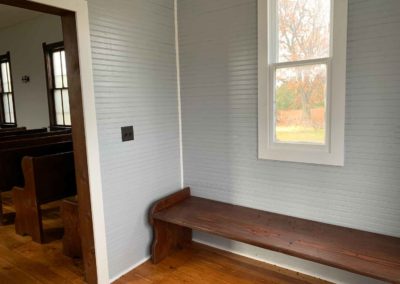 view of north wall of vestibule with window and bench