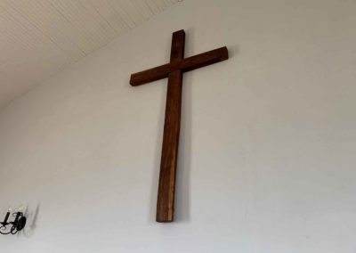 close up image of large wooden cross on back wall of chapel
