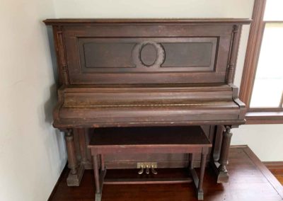 antique upright piano on stage of chapel
