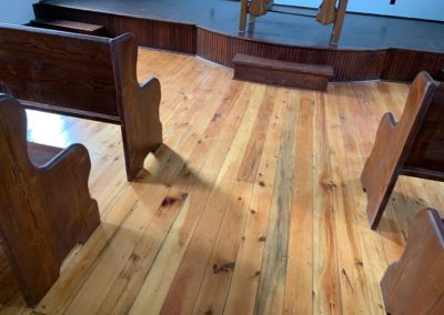 view of hard wood floor and wooden pews in chapel