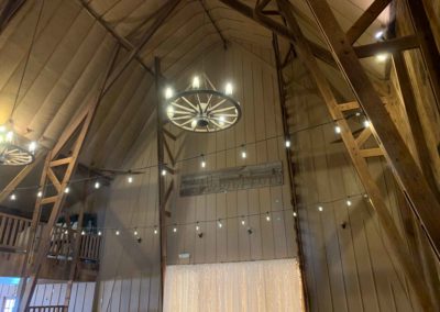 looking up at the wagon wheel chandelier and East door in the Big Red Barn