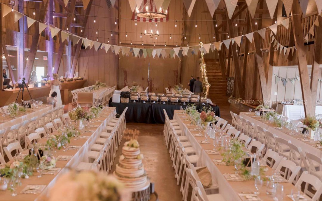 hanging banners, and numerous white tables and chairs filling the Big Red Barn